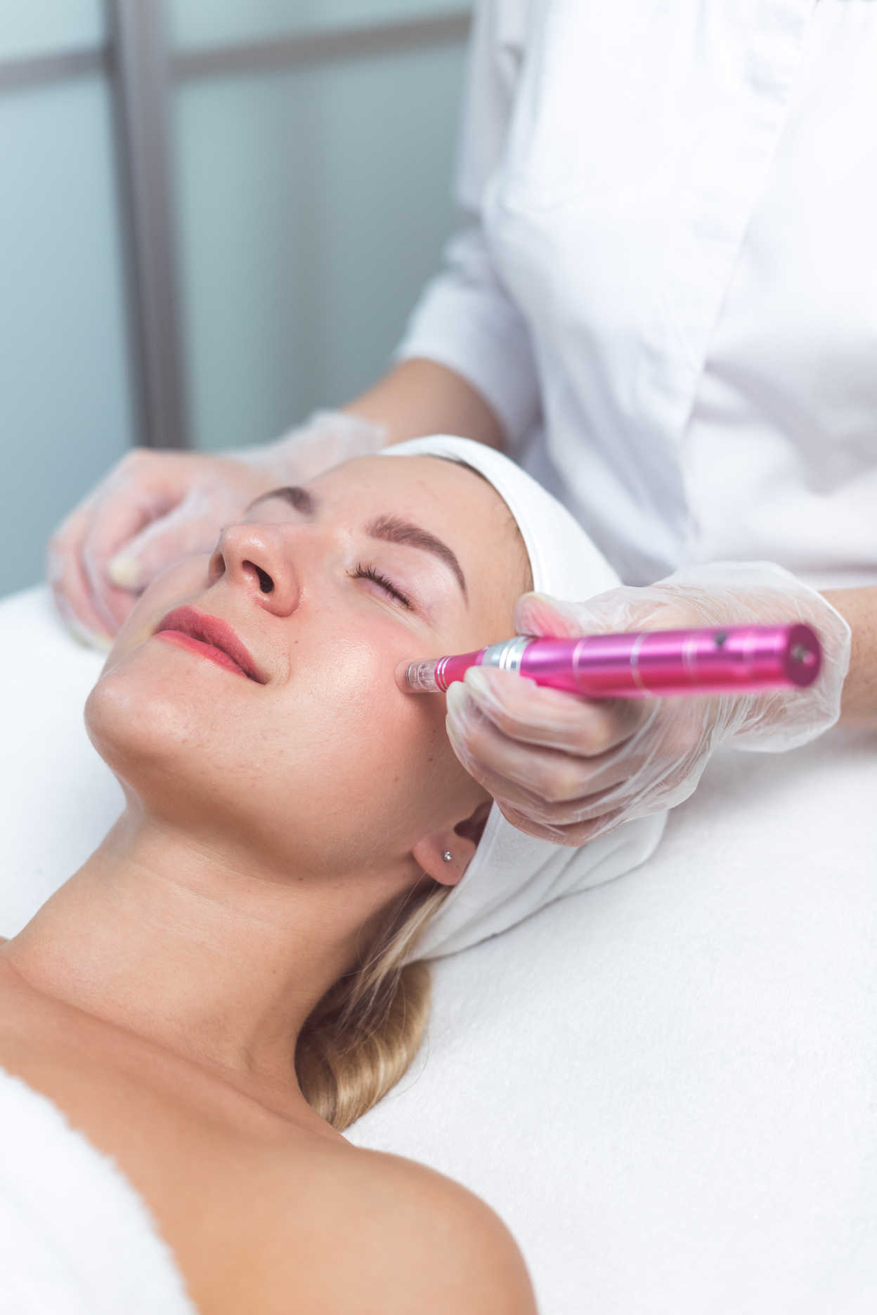 Woman Having Facial Treatment with Derma Pen in Beauty Salon